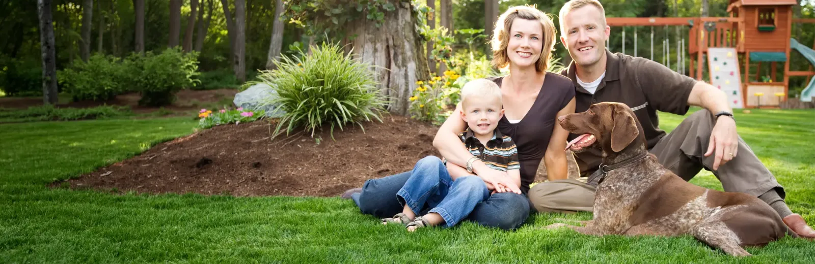 Family outside with dog playing