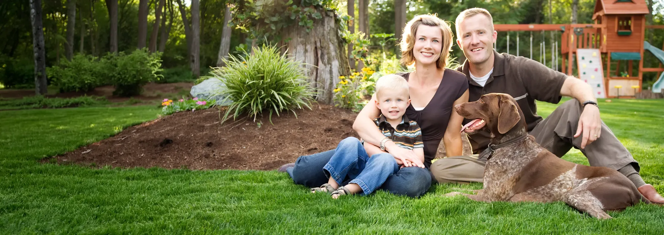 Family outside with dog playing
