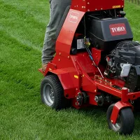 Aerating lawn, technician riding aerator 